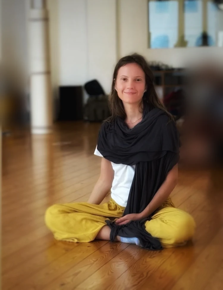 Hanna Teike, Feldenkrais-Praktizierende in Ausbildung, im Schneidersitz in einem Bewegungsraum
